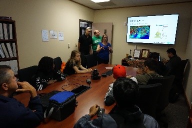 Students stting at table watching presentation