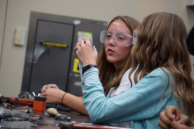 Two female students working at table