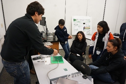 Researcher showing electrical board to students