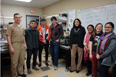 Soldier with professor and students in a lab